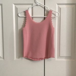A pink tank top with half circular edges